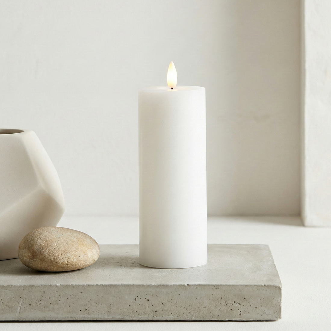 LED Indendørs Bloklys Ø6 x H15 cm i hvid voks og plast med realistisk flamme, batteridrevet, sikkert og vedligeholdelsesfrit.