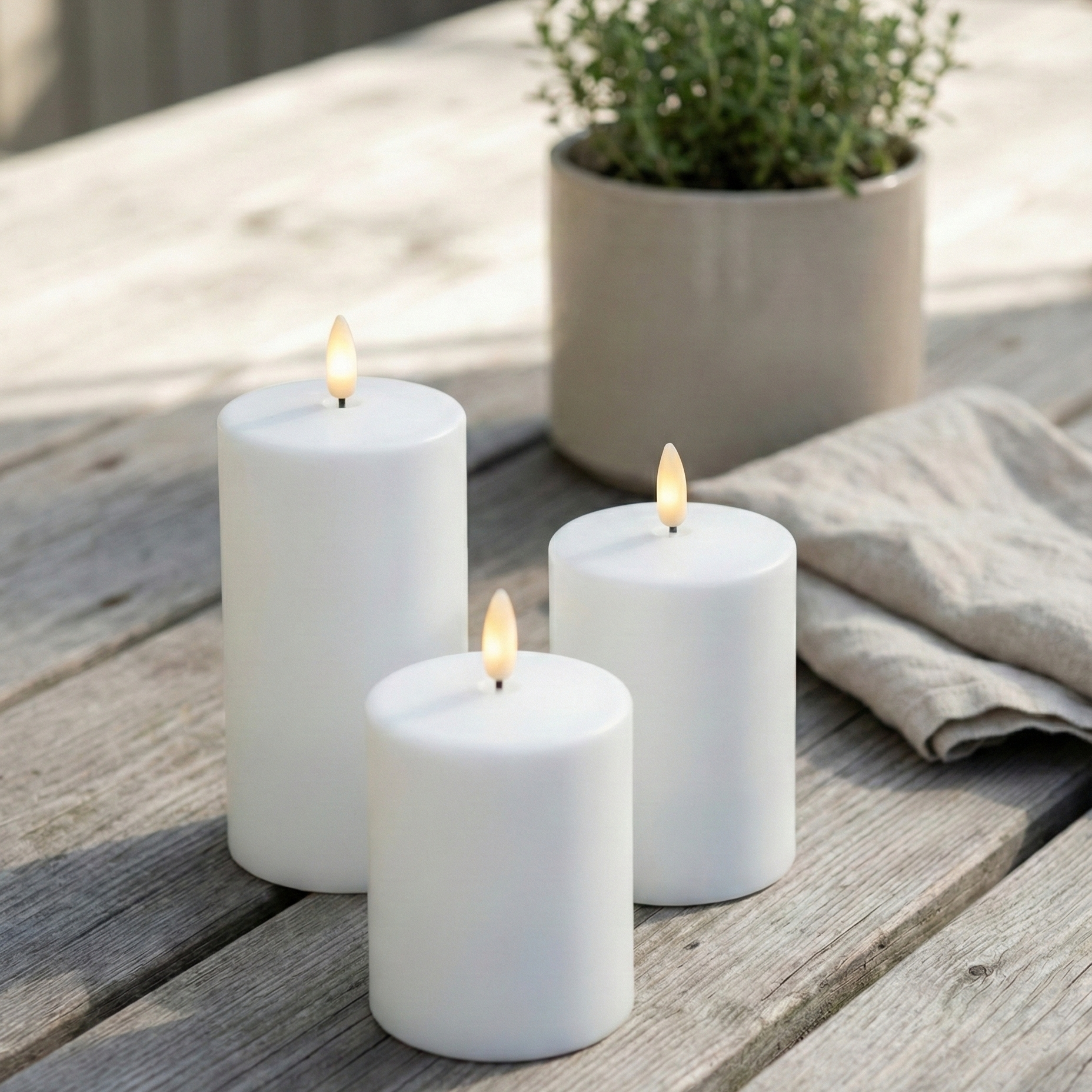 Udendørs LED bloklys Ø7 cm i hvid med naturtro flammer, fjernbetjening og timerfunktion – perfekt til terrasse, altan og have.