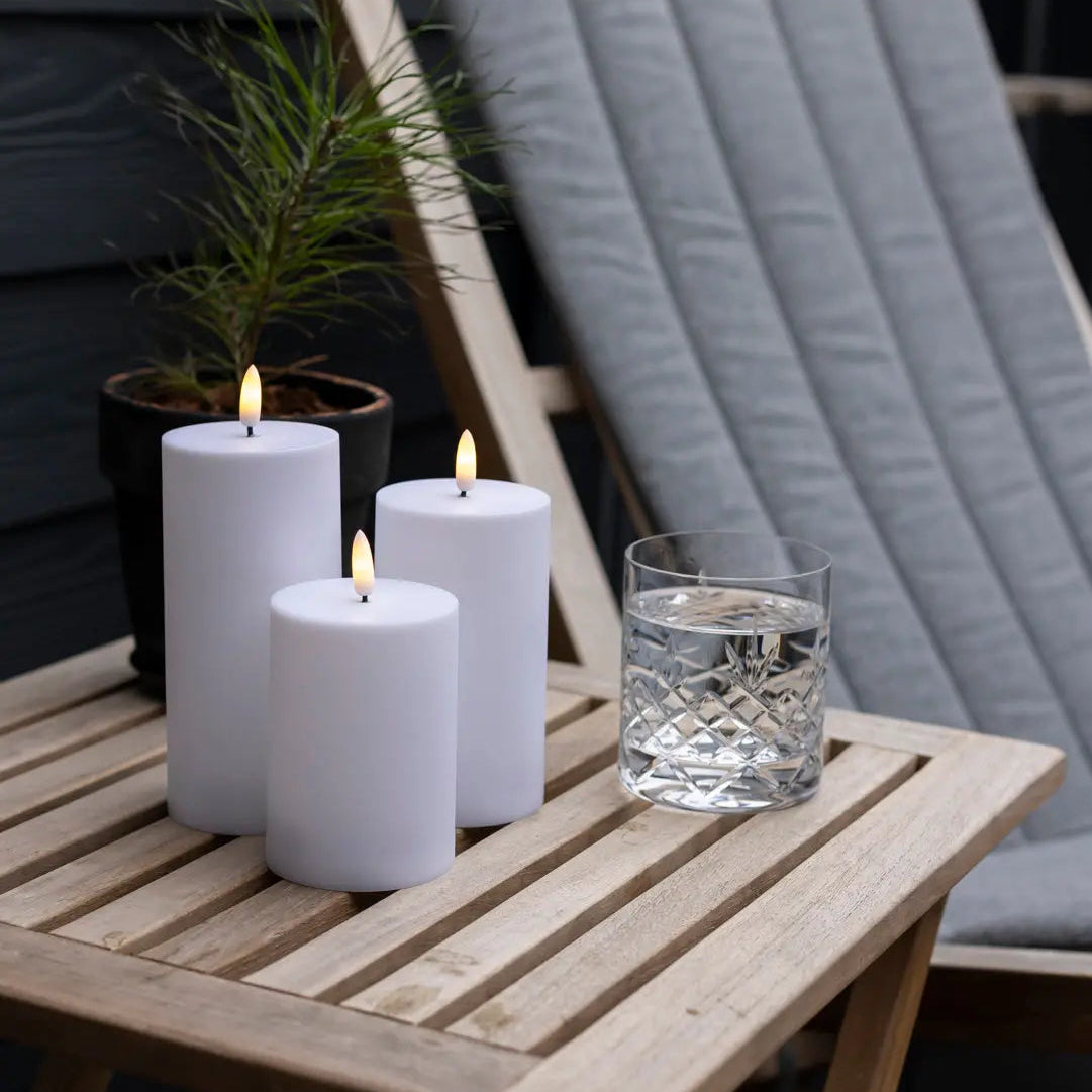 Udendørs LED bloklys Ø7 cm i hvid med naturtro flammer, fjernbetjening og timerfunktion – perfekt til terrasse, altan og have.