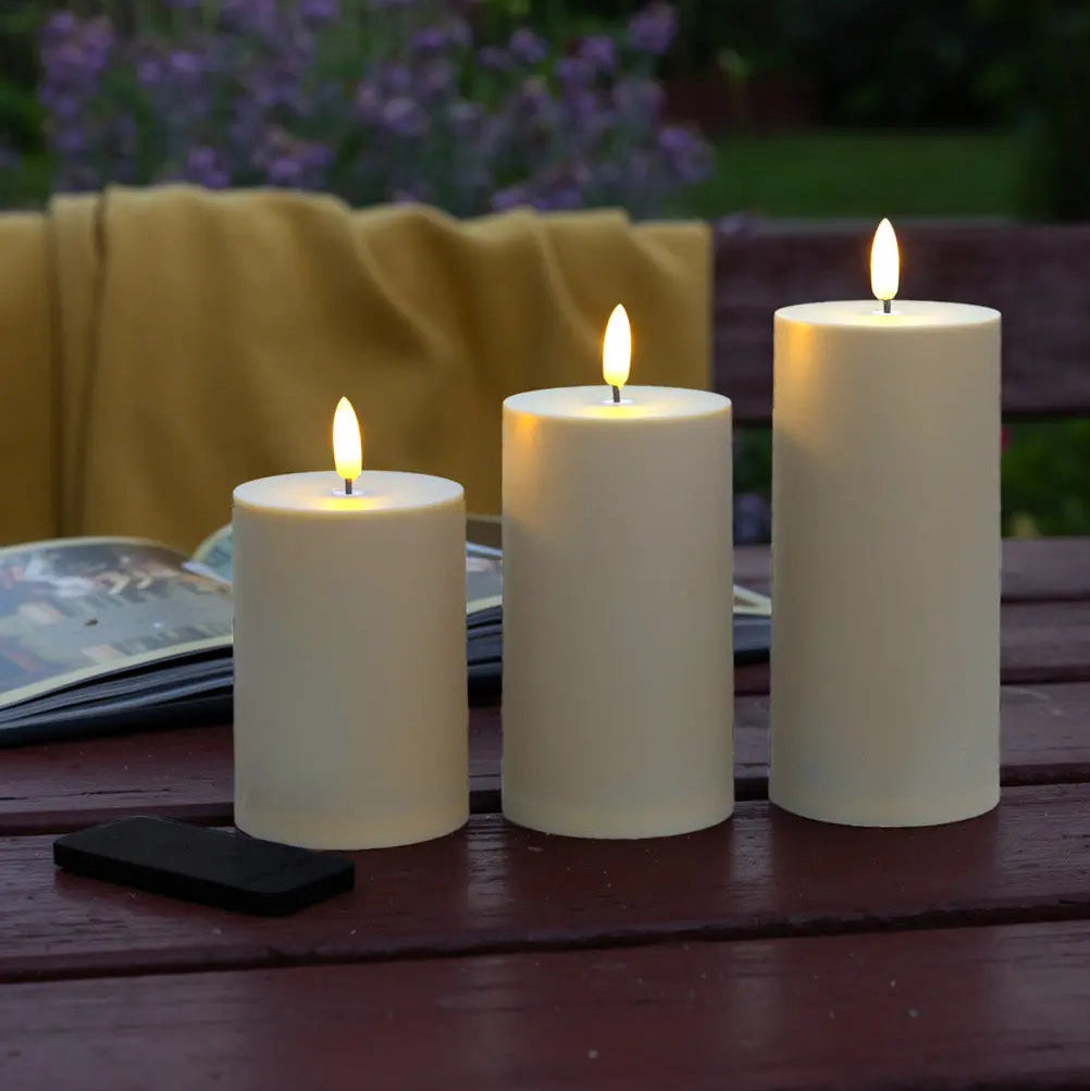 Udendørs LED bloklys Ø7 cm i sandfarve med naturtro flammer, fjernbetjening og timerfunktion – ideelt til terrasse, altan og have.